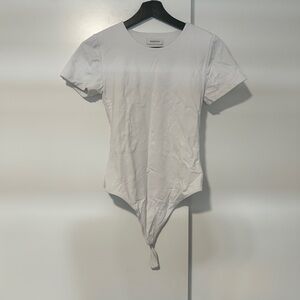 white bodysuit with a sculpted, body-contour.